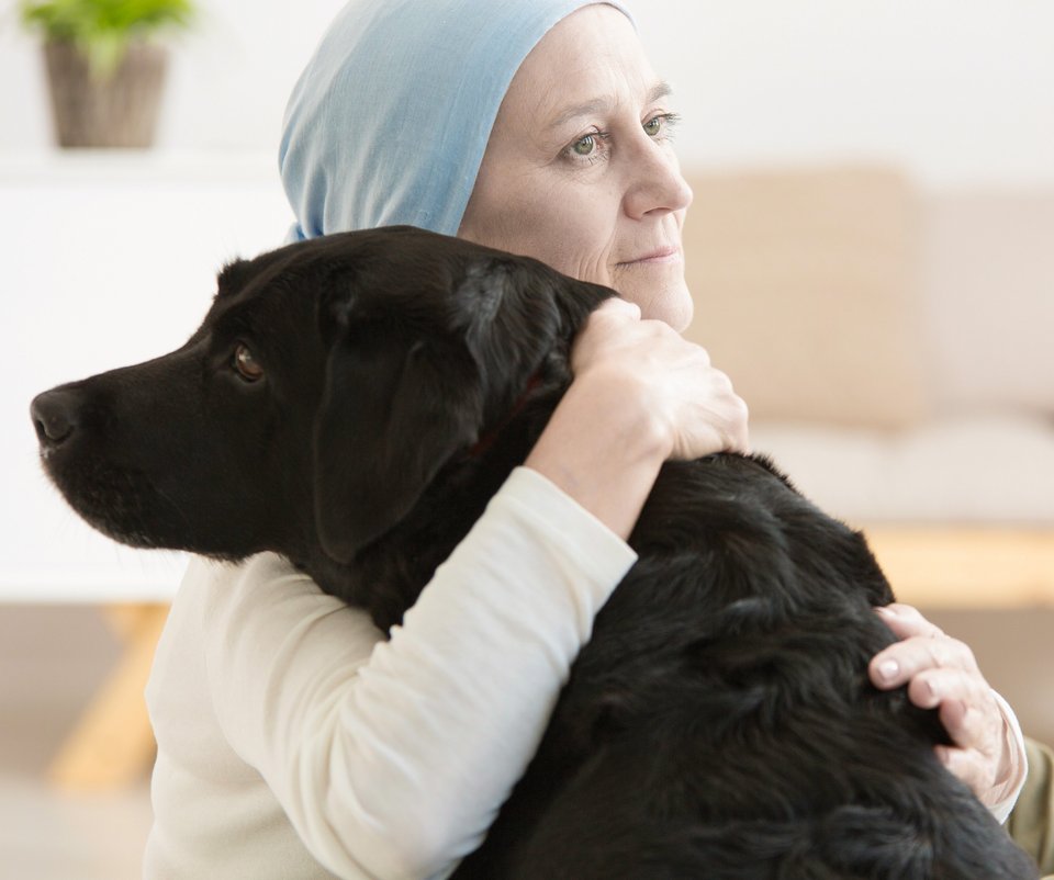 Onkologiepatientin umarmt Hund